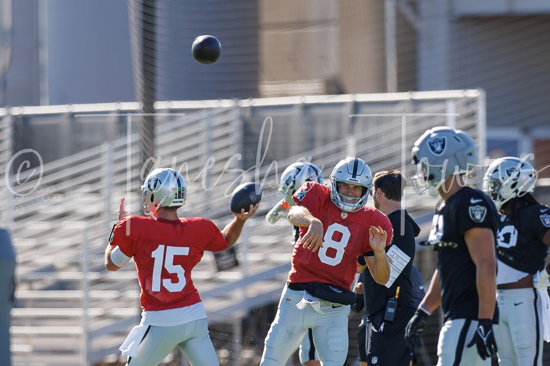 Raiders QBs wearing numbers 15 and 8 throw passes during NFL training camp practice on a sunny day.