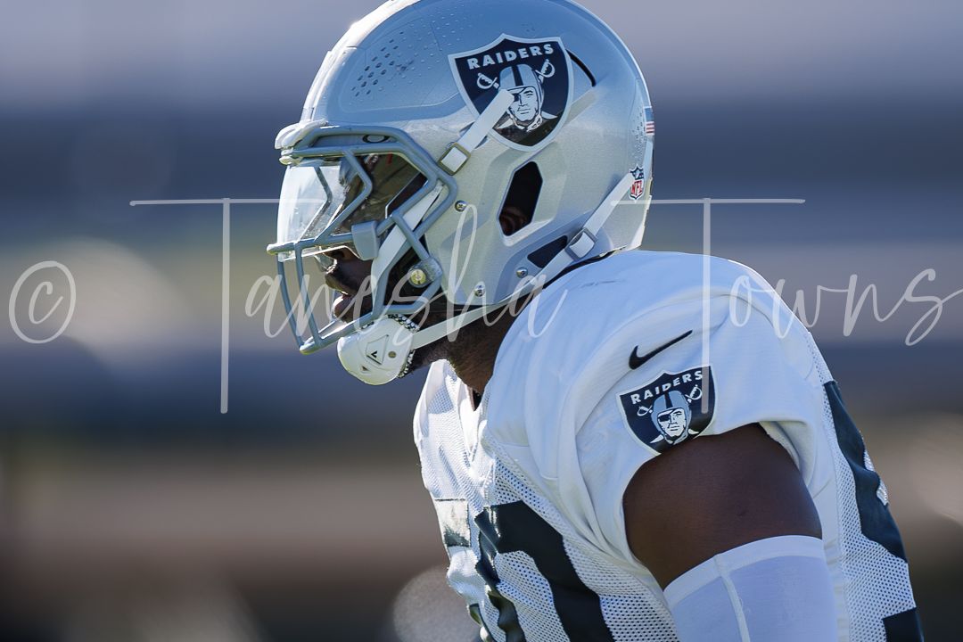 Las Vegas Raiders player wearing white uniform and silver helmet with Raiders logo during practice.