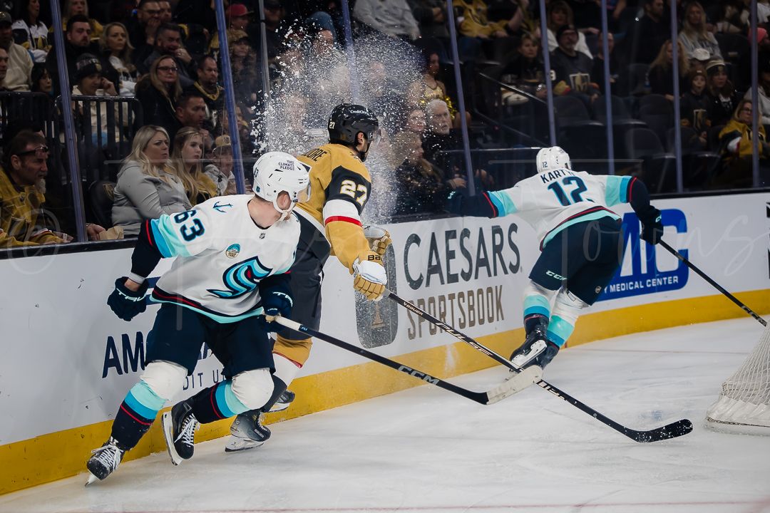 NHL players scramble for the puck along the boards during a competitive game.