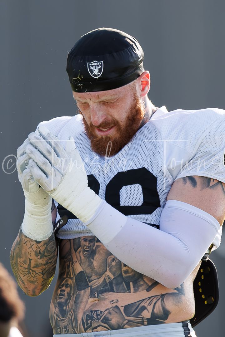 Tattooed Las Vegas Raiders lineman with beard wearing black Raiders bandana at practice.