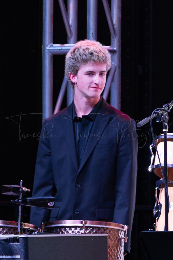 Student musician performing on percussion instruments during a jazz band performance.