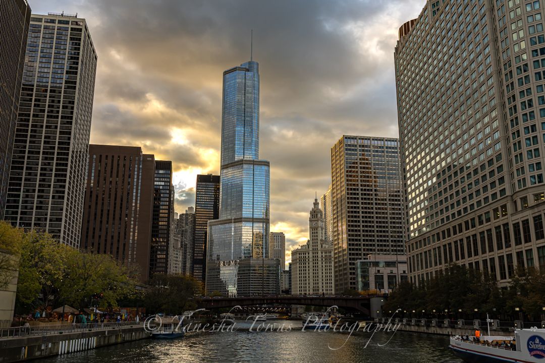 Urban panorama of Chicago's riverside architecture with dramatic cloudy skies at golden hour.
