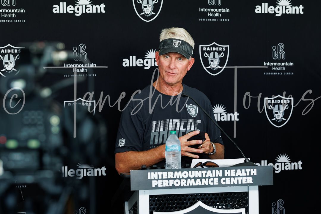Las Vegas Raiders head coach speaks at podium during press conference at Intermountain Health Performance Center.