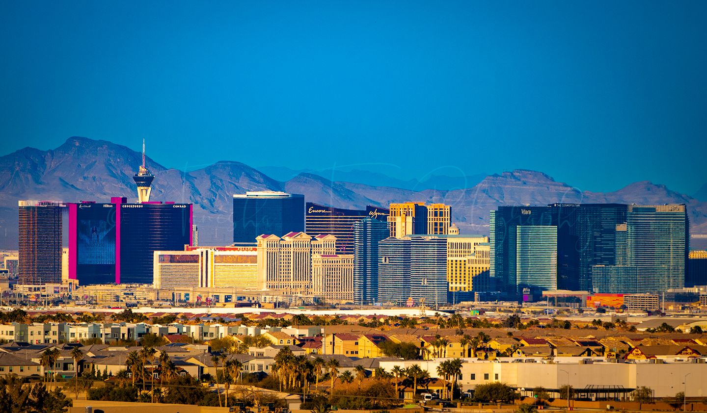Panoramic cityscape of Las Vegas with mountains and desert landscape in the background.
