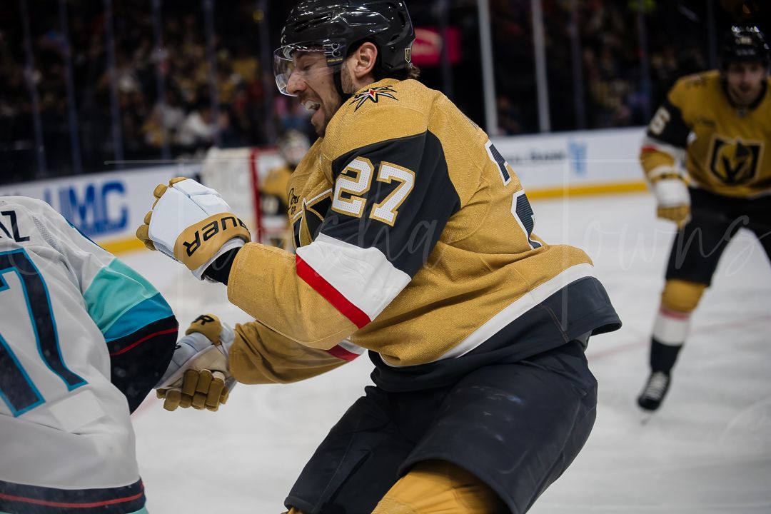 Players from two hockey teams fight for possession near the boards during a professional match.