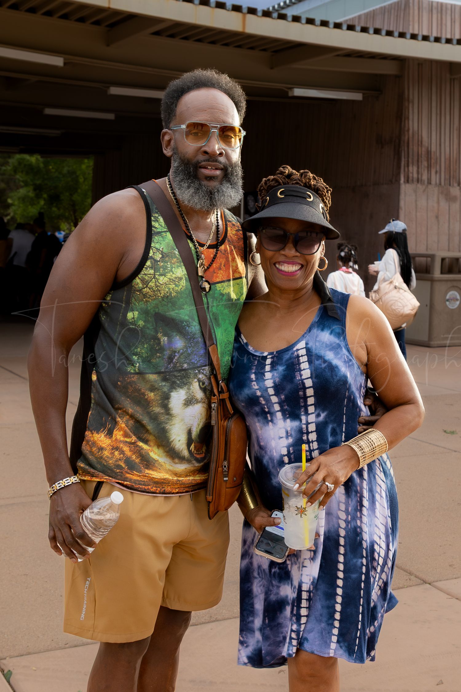 Couple in tie-dye and casual summer clothing at outdoor community event.
