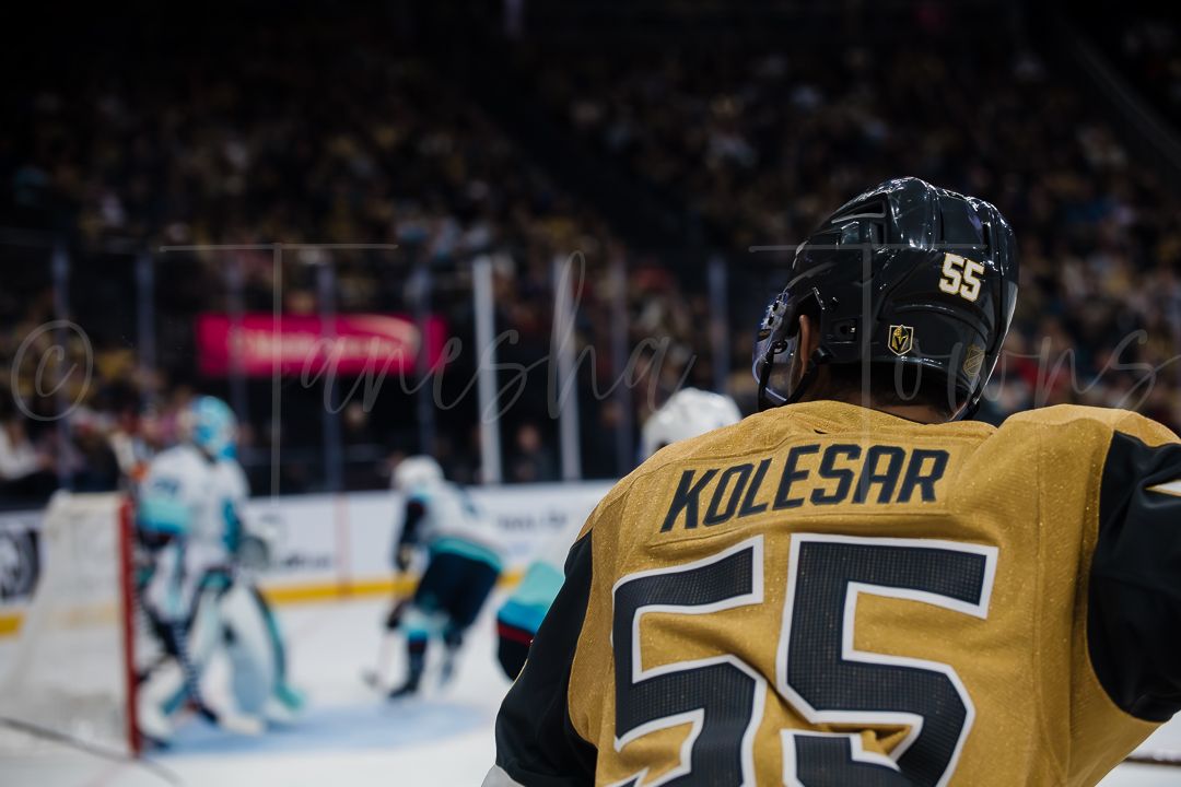 NHL hockey player wearing jersey number 55 skates on ice during professional game action.