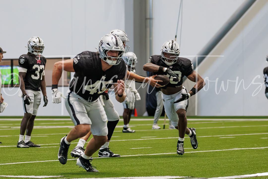 Raiders offensive linemen practice blocking assignments during indoor training camp.