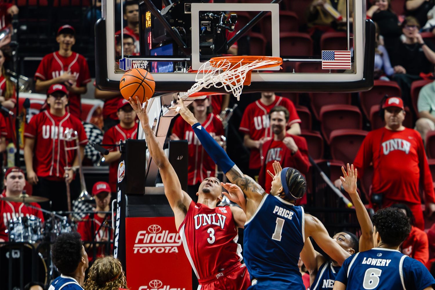 UNLV Runnin' Rebels player #3 attempts a layup against Nevada Wolf Pack defenders during an intense college basketball game.