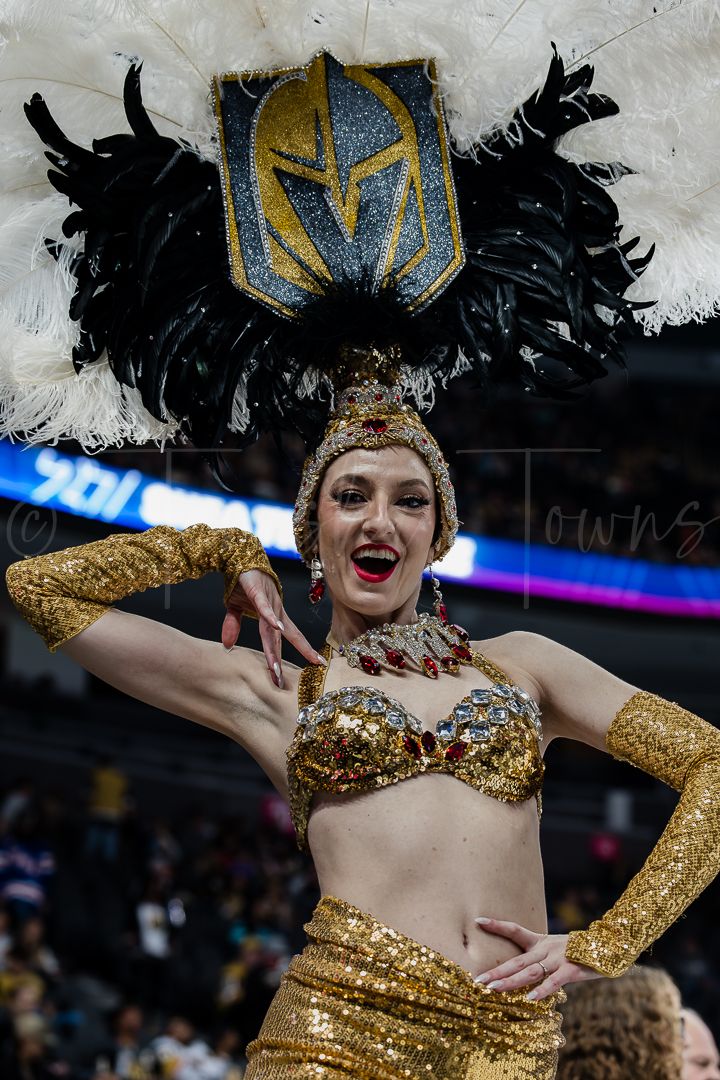 Vegas Golden Knights ice crew performer in gold costume entertains during game break.