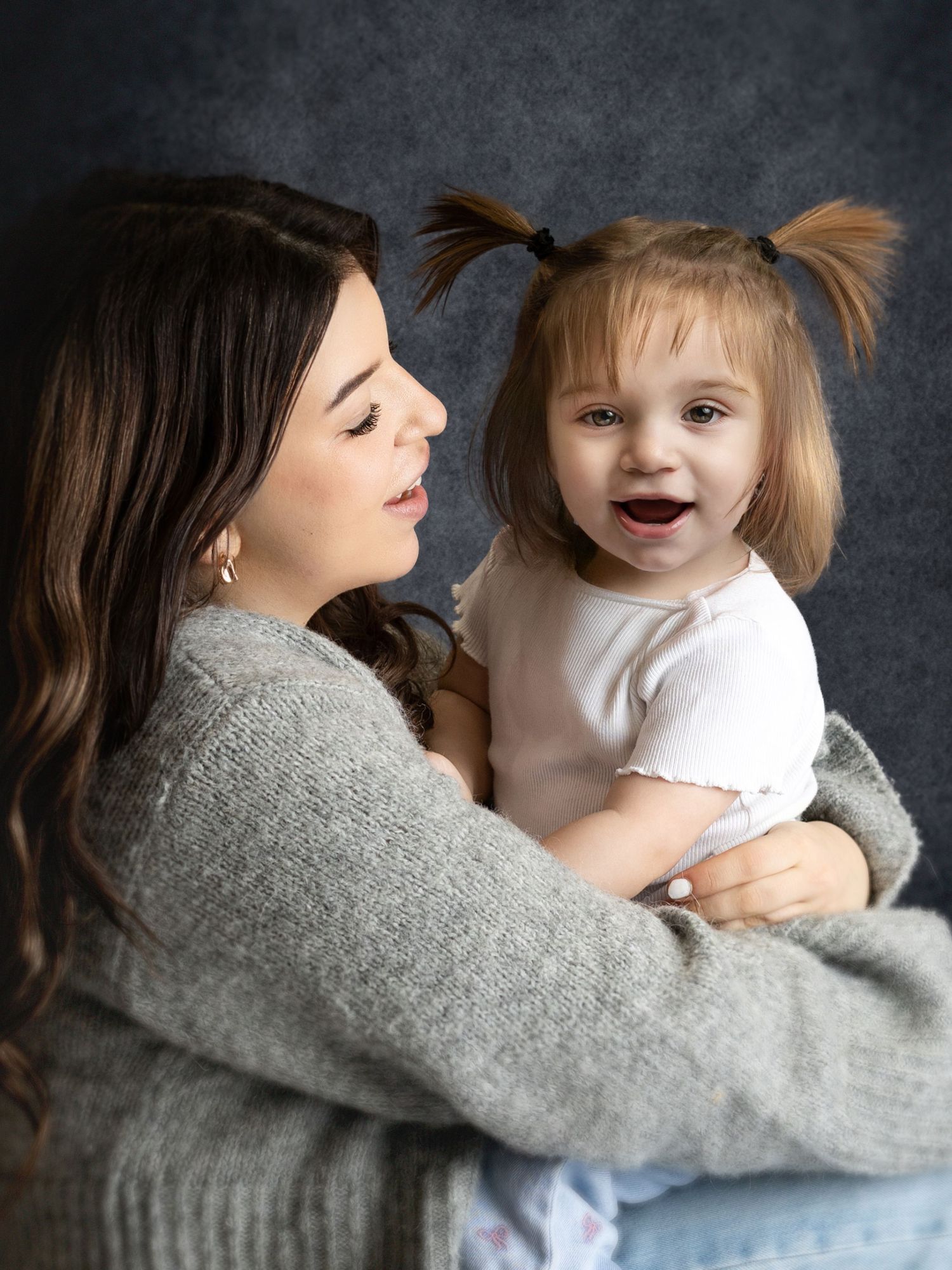 A heartwarming sequence of candid moments between parent and child showing playful interaction against a dark backdrop.