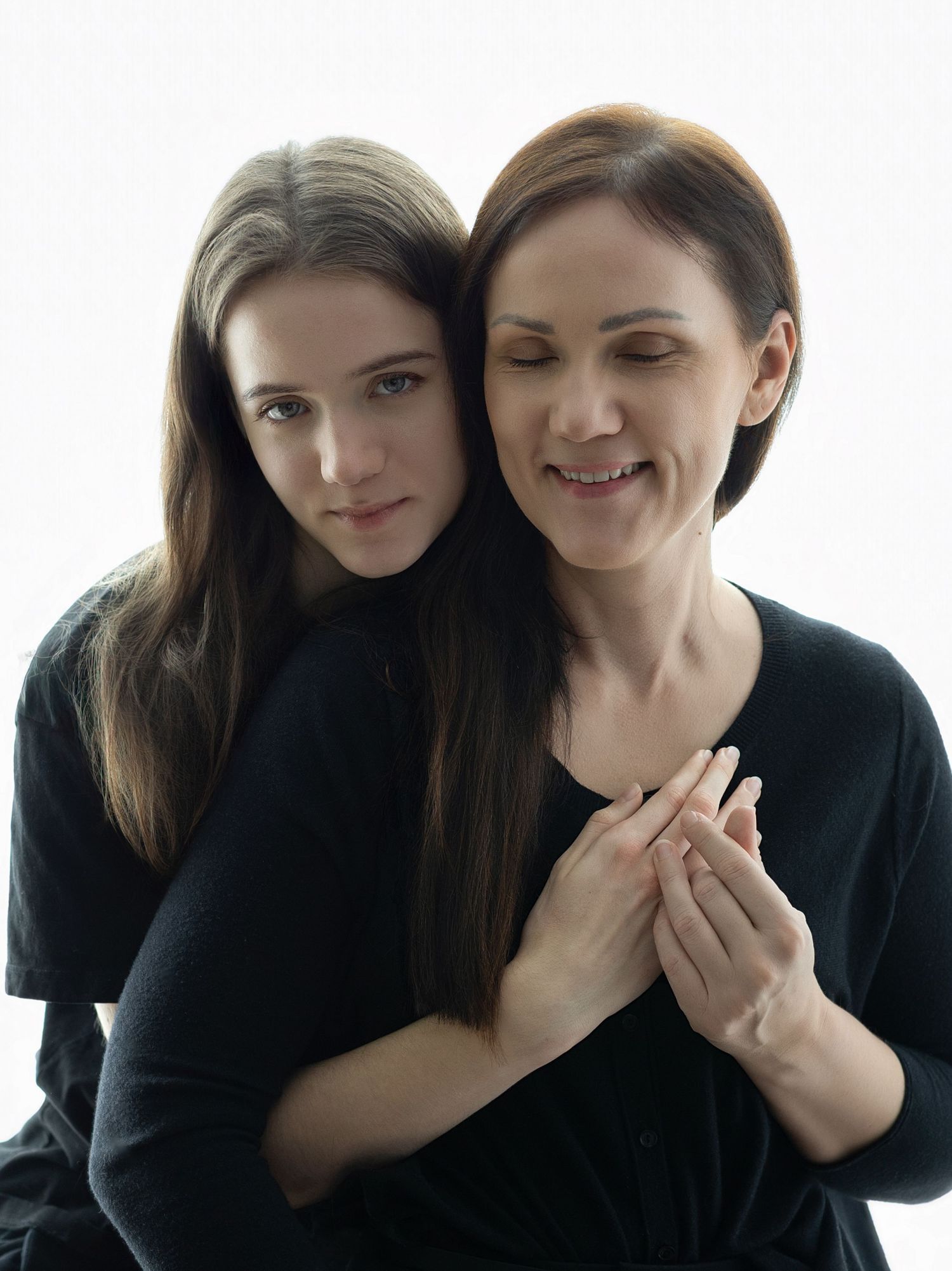 A series of four black and white portrait photos showing two people in intimate poses against a white background.