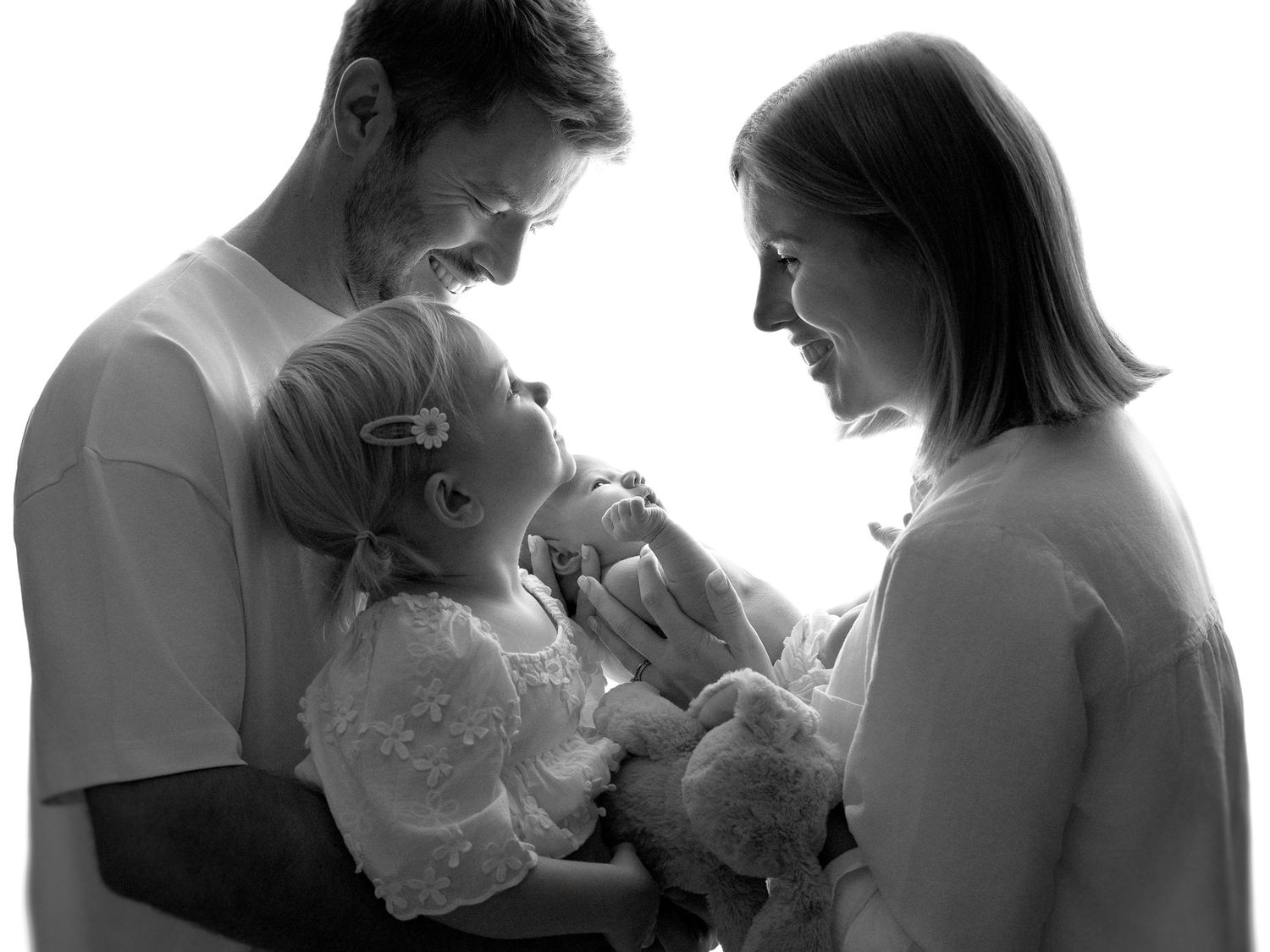 Artistic black and white photo series showing intimate family moments with a newborn baby.