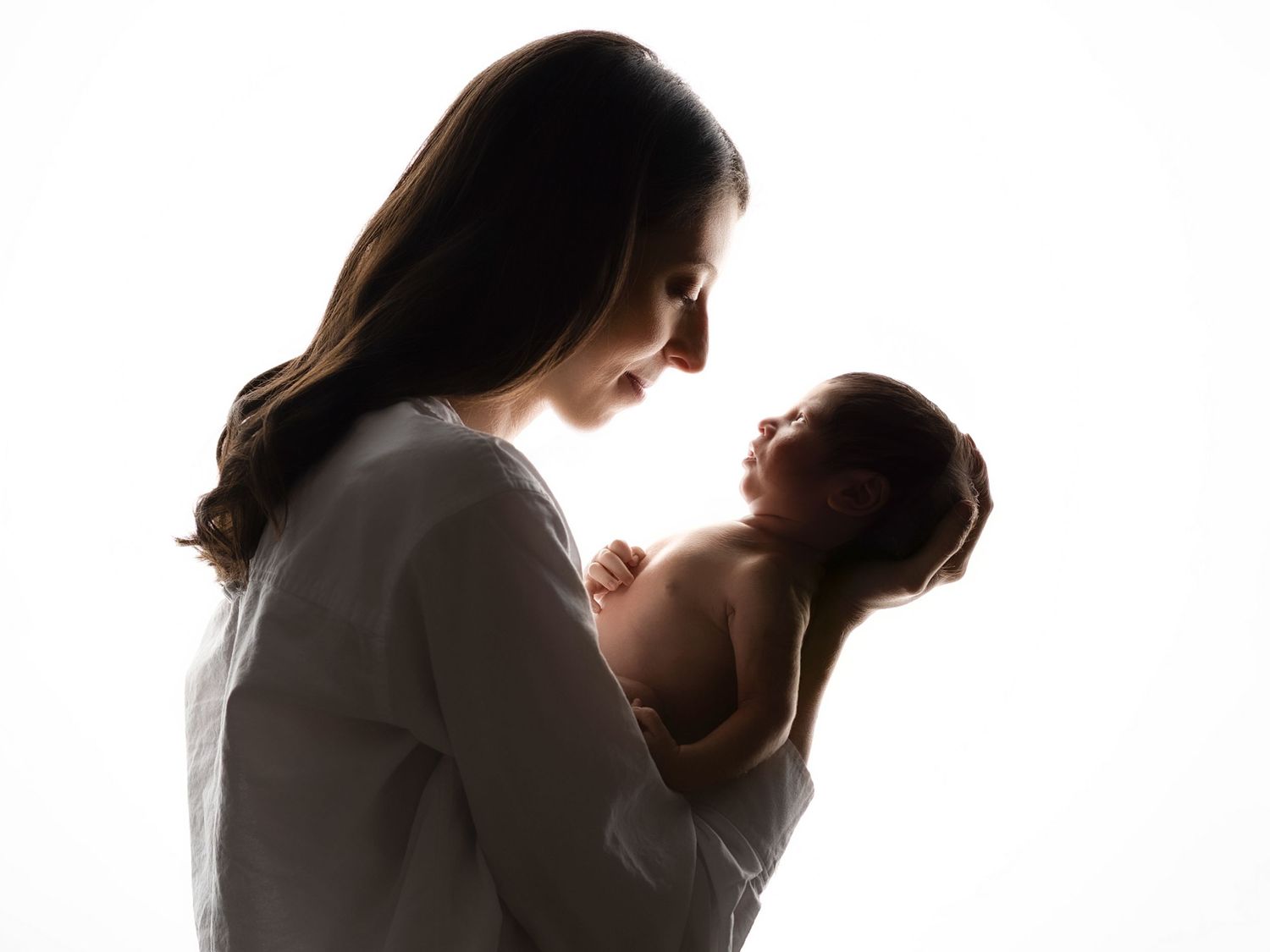 Silhouette portraits of mother and child in dramatic lighting.