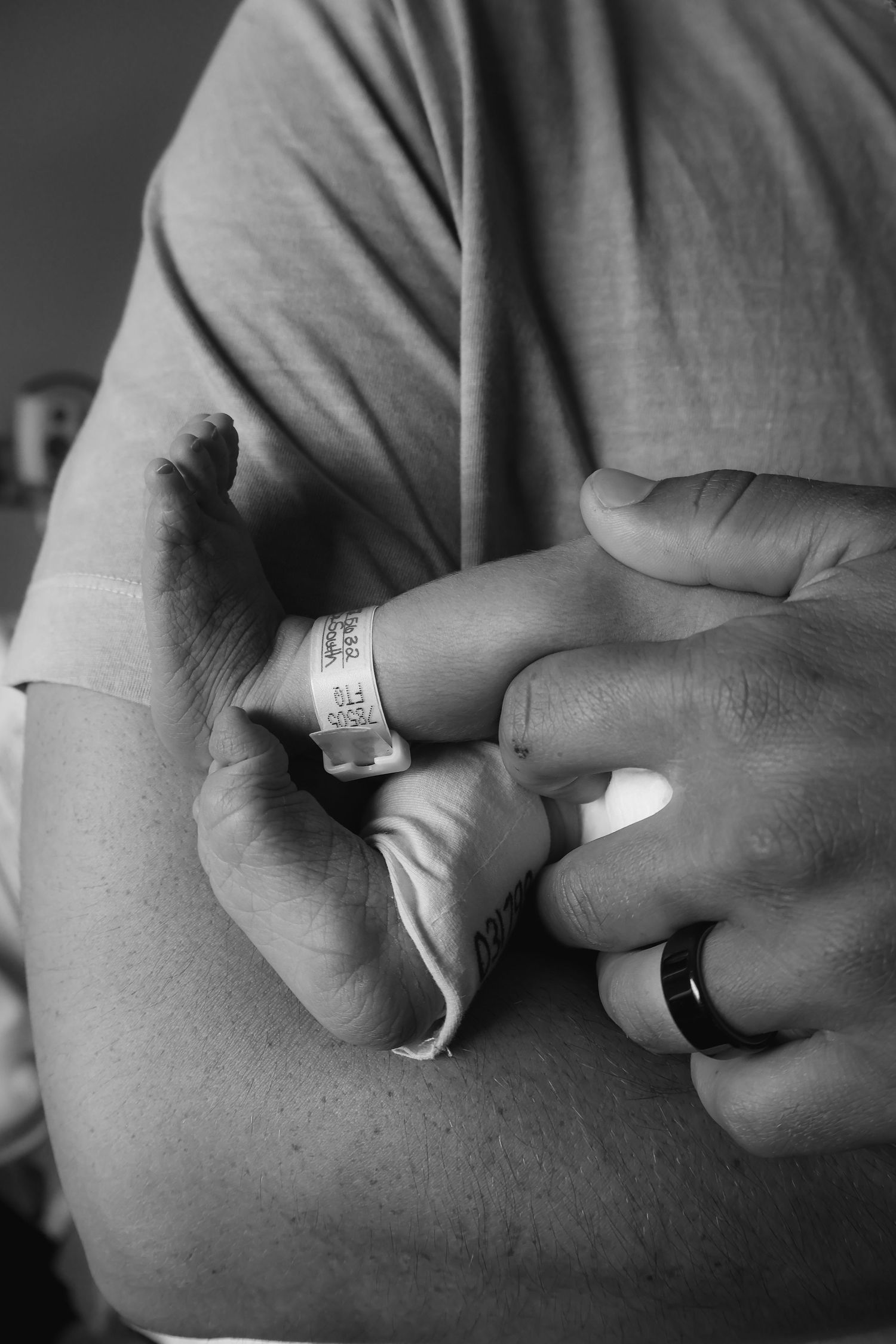 Close-up black and white photo of hospital identification bracelet on person's wrist.