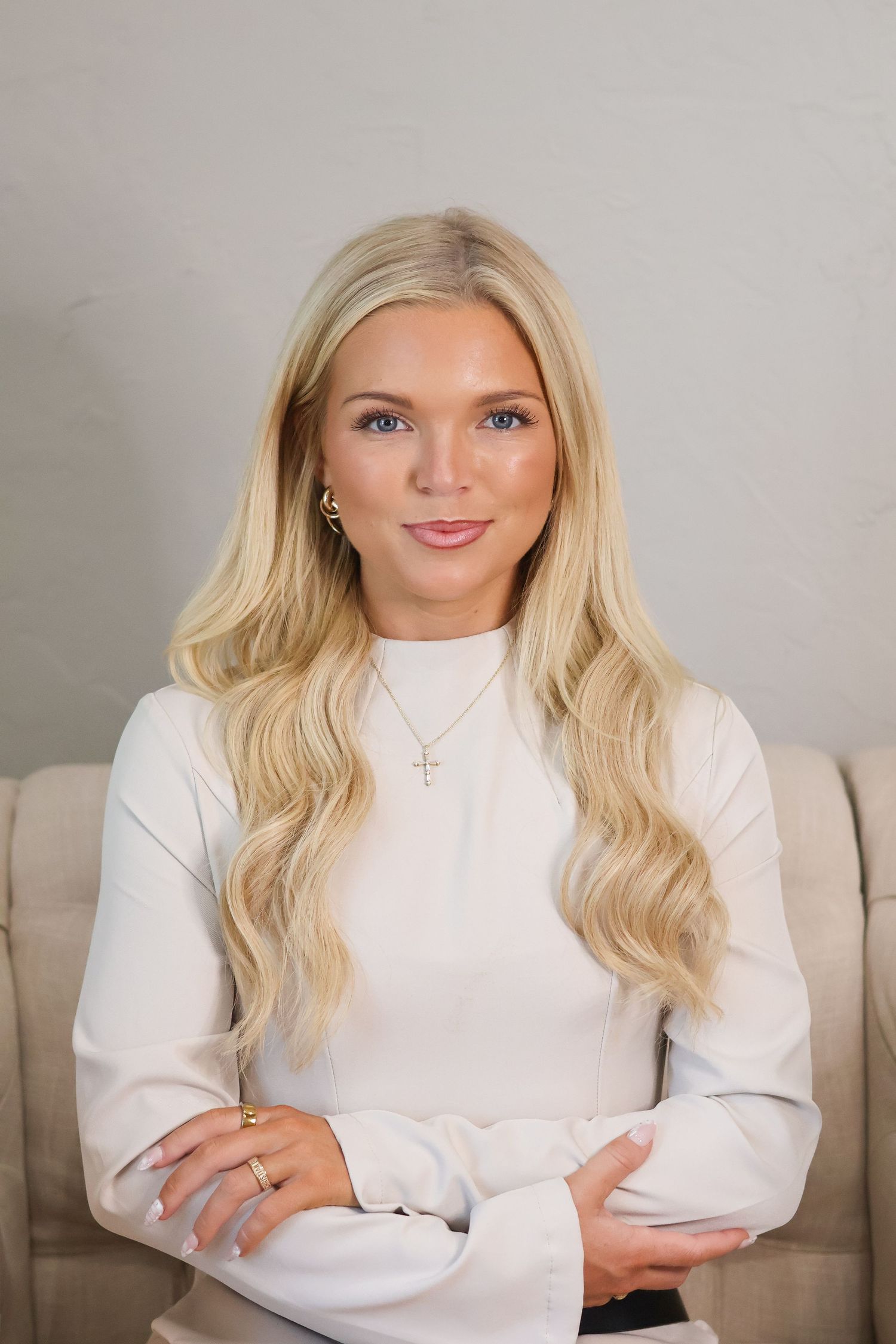 Person wearing white turtleneck and delicate necklace in professional studio portraits.
