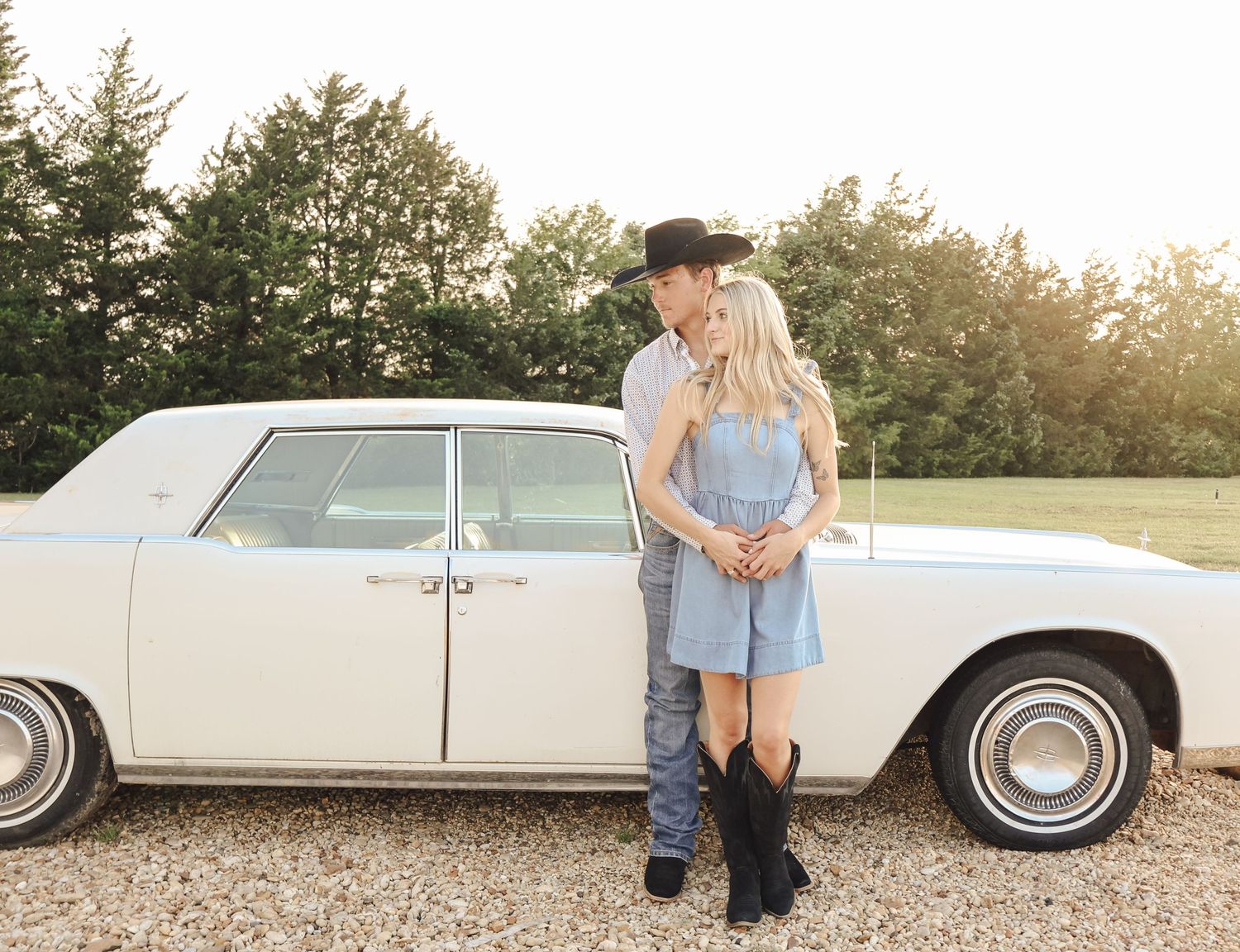 Vintage white car serves as backdrop for a romantic countryside photoshoot.