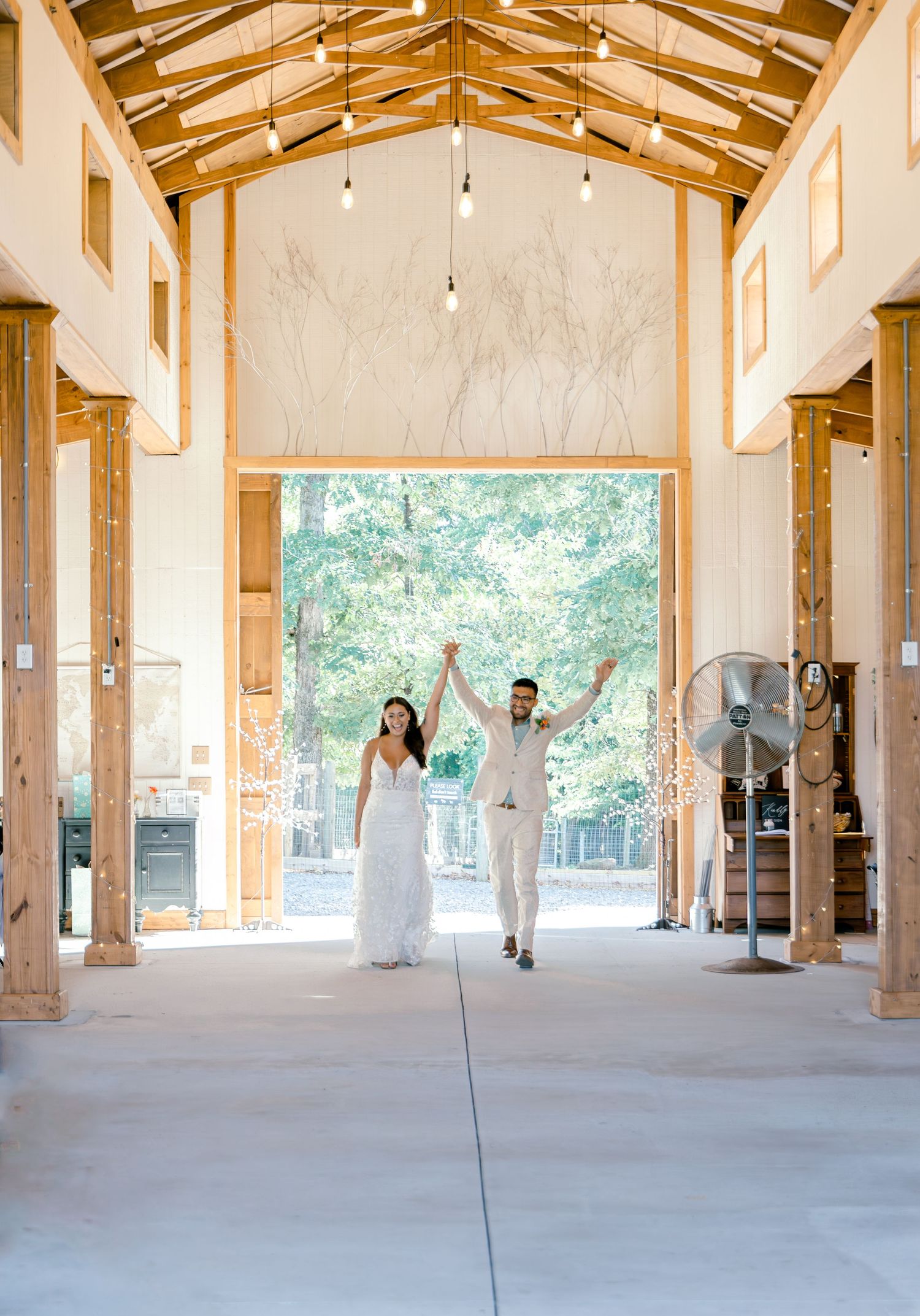 An elegant rustic wedding venue interior with wooden beams and string lights.