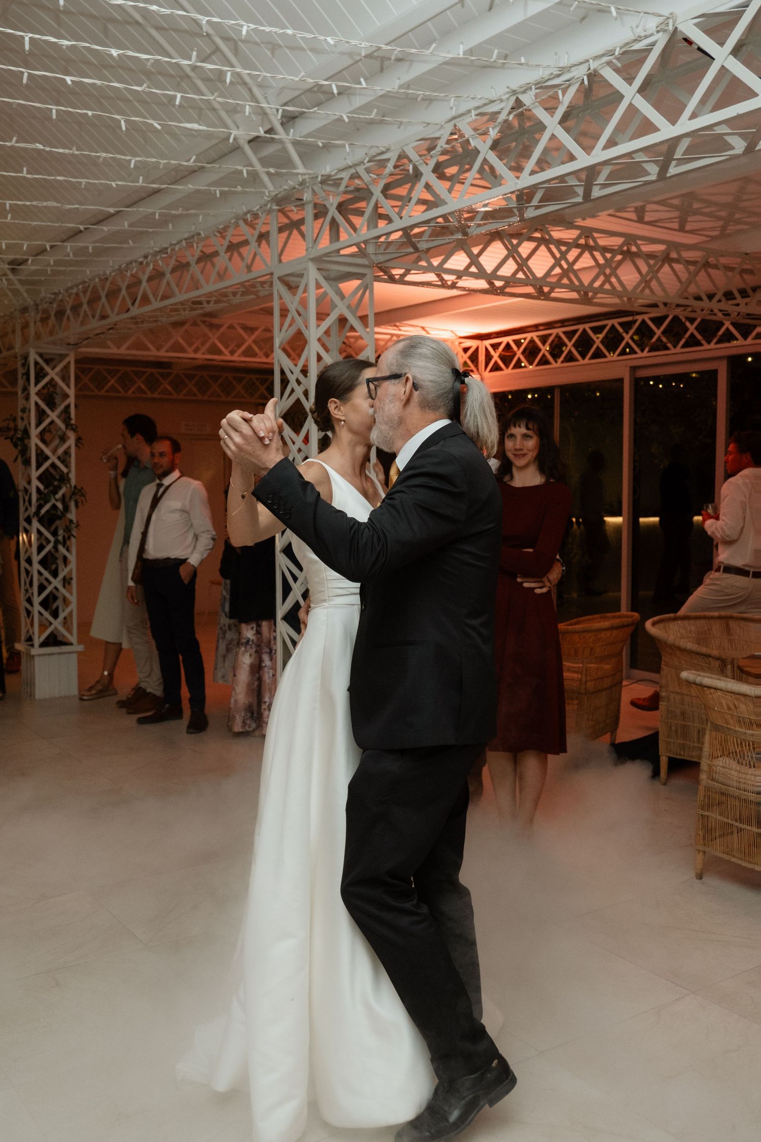 Bride and groom share their first dance in an elegant decorated reception venue with warm lighting.