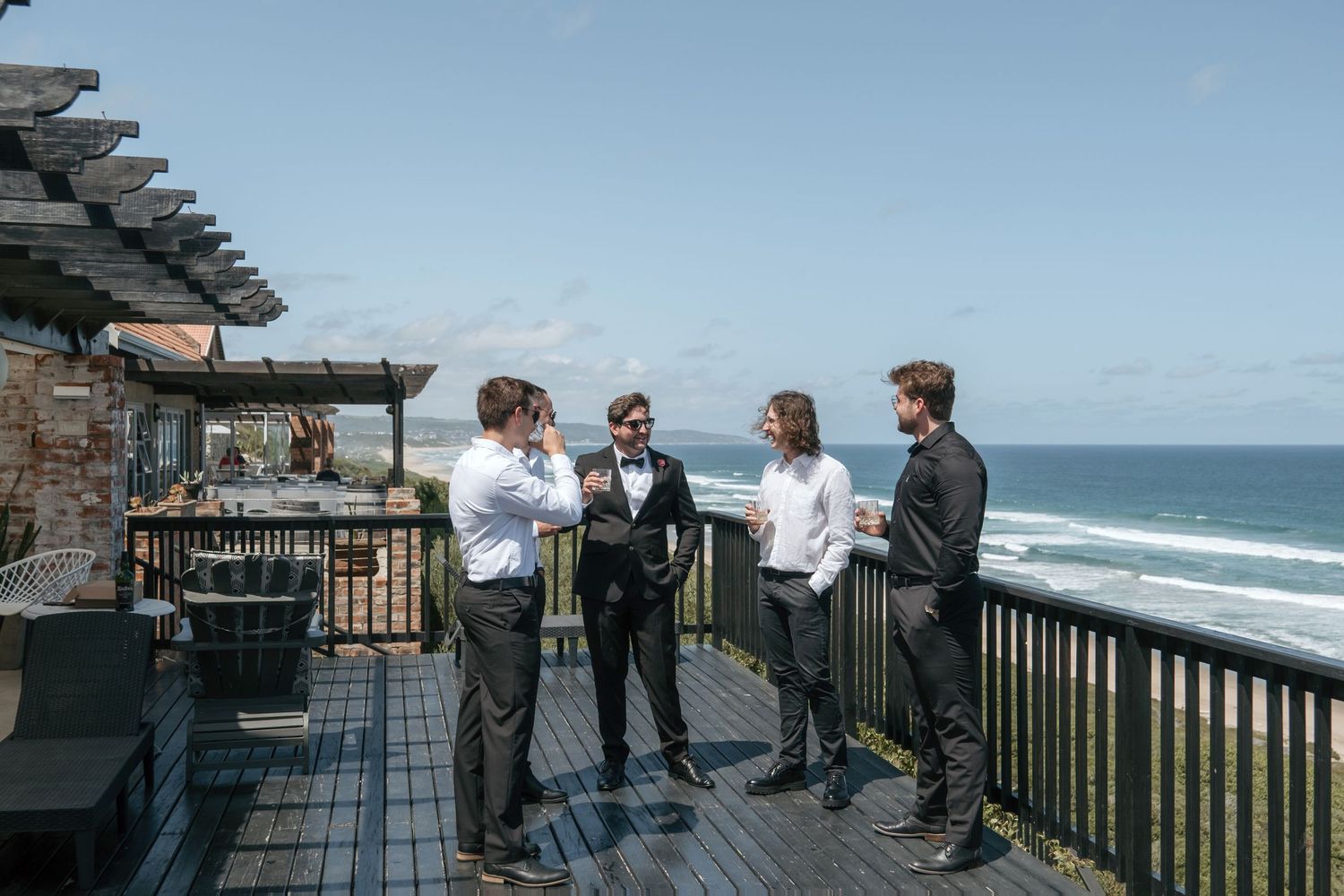 Wedding party gathered on oceanfront deck during preparations  at Seeplaas Wedding Venue.