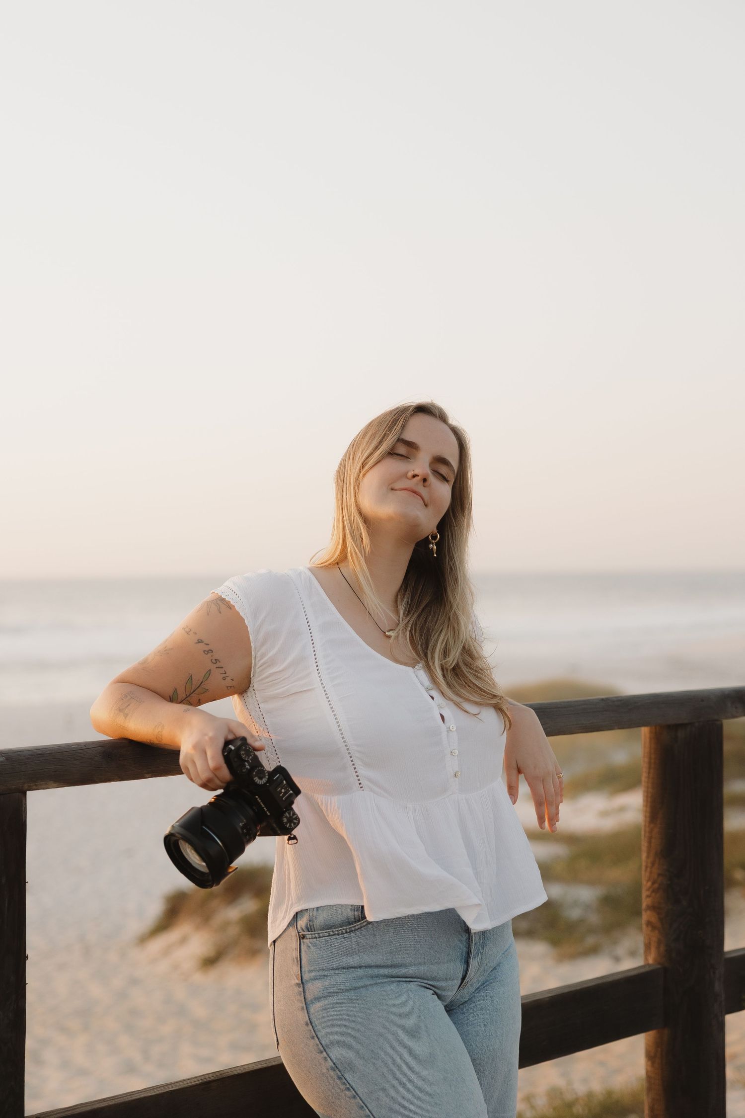 Woman in white t-shirt leaning on wooden railing at beach during sunset in artistic photo sequence.