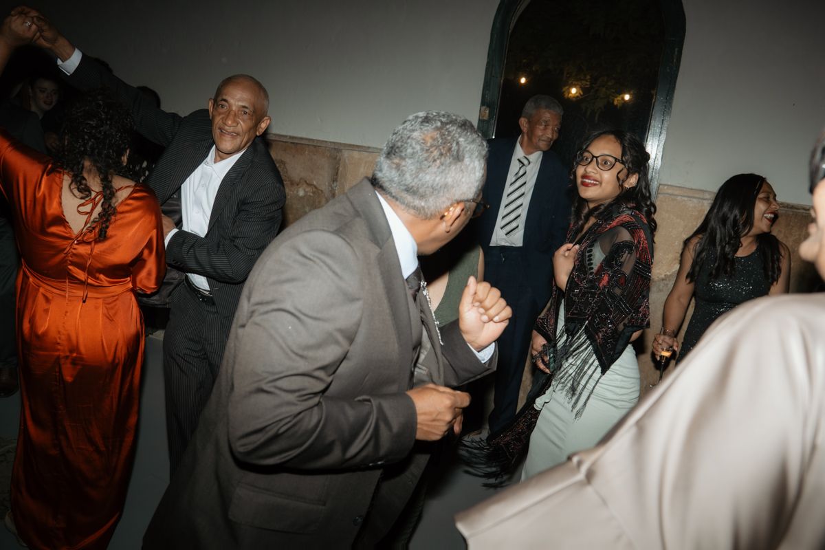 Wedding guests dance and celebrate joyfully in elegant venue during lively evening reception party.