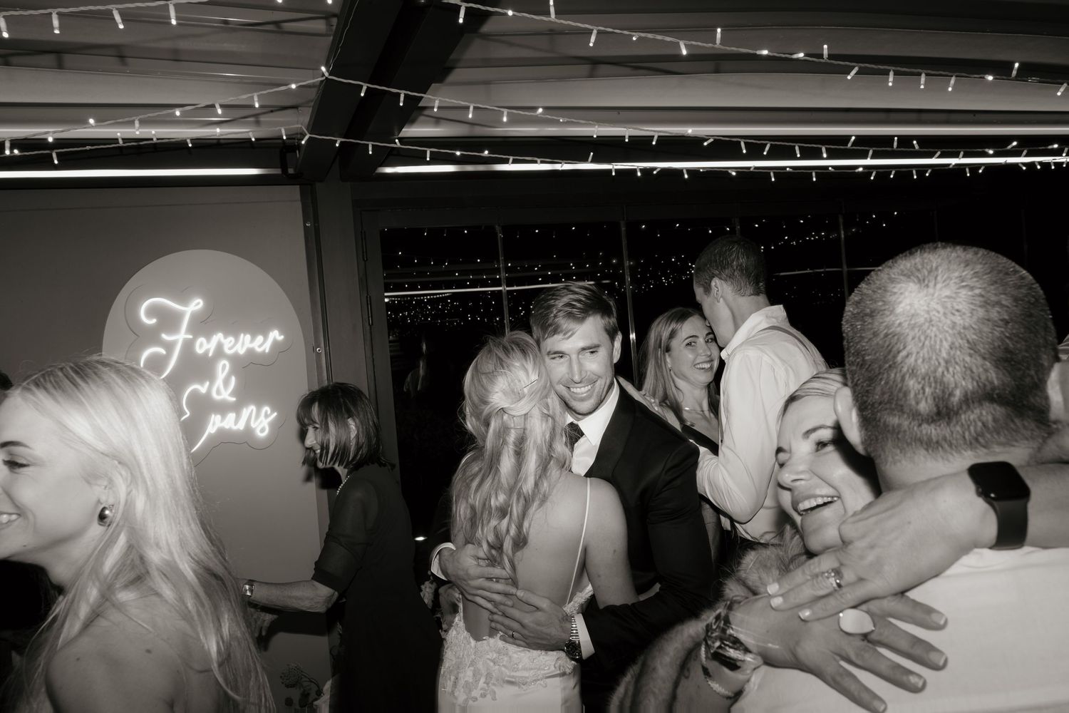 A romantic wedding reception celebration with dancing and embracing couples in a dimly lit venue at BOSJES Wedding Venue