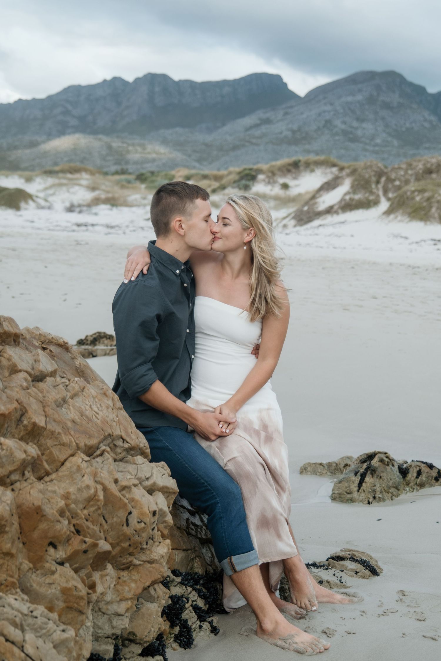 Romantic beach portrait with dramatic mountain landscape in background in Pringle Bay