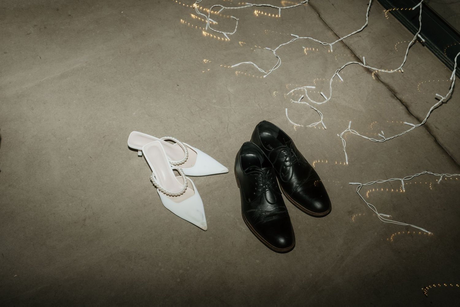 Black dress shoes and chalk drawings on a concrete floor.