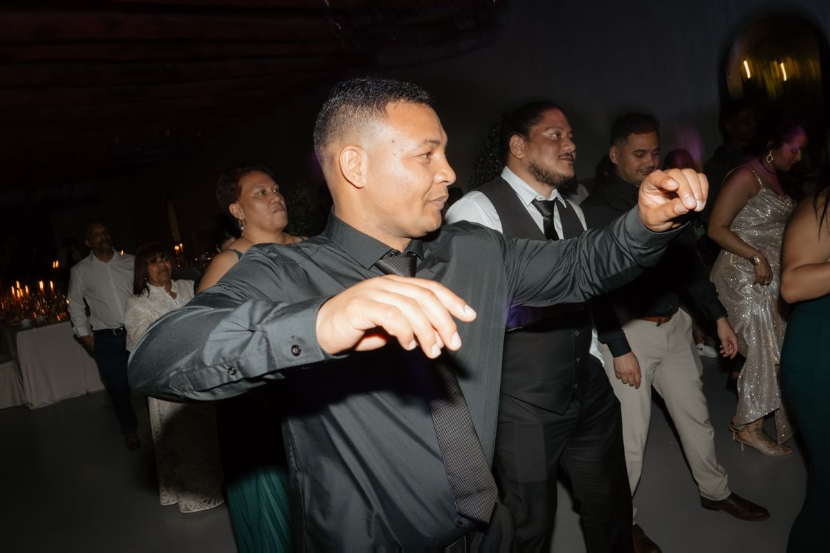 Male wedding guest dancing energetically on the dance floor at a festive evening wedding reception.