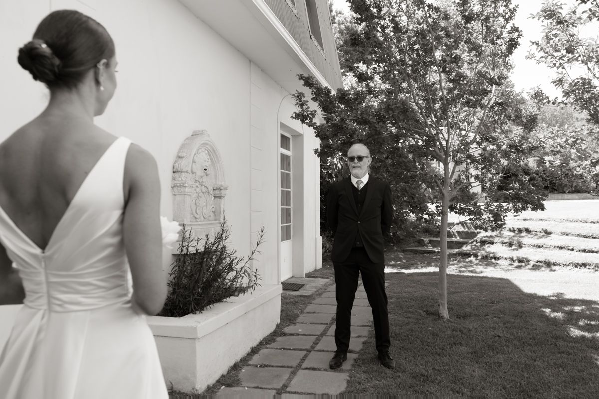 Black and white photo of groom seeing bride for the first time during wedding first look.