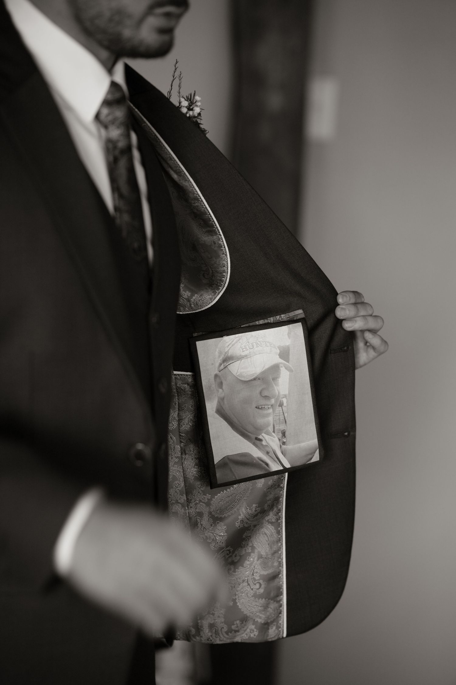 Groom reveals photo of loved one tucked inside suit jacket pocket as heartfelt wedding day tribute.
