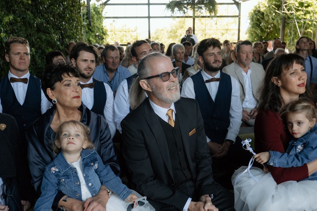 Wedding guests seated and watching ceremony with children in foreground.