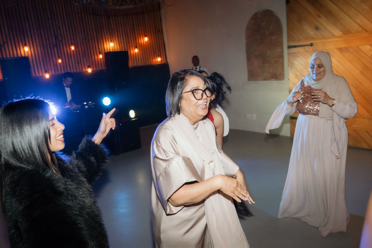Wedding guests dance and celebrate joyfully on the dance floor at a lively reception.