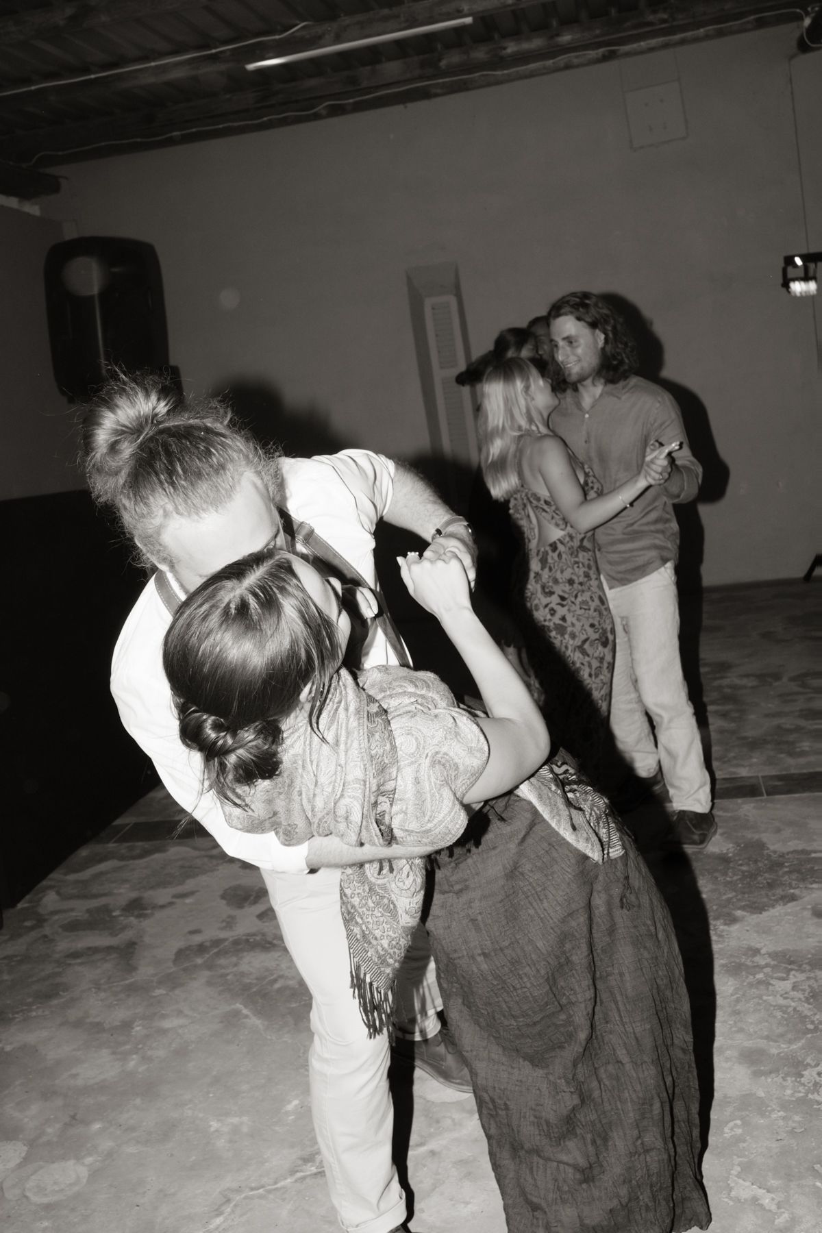 Black and white photo of couples dancing closely together at romantic wedding reception party.