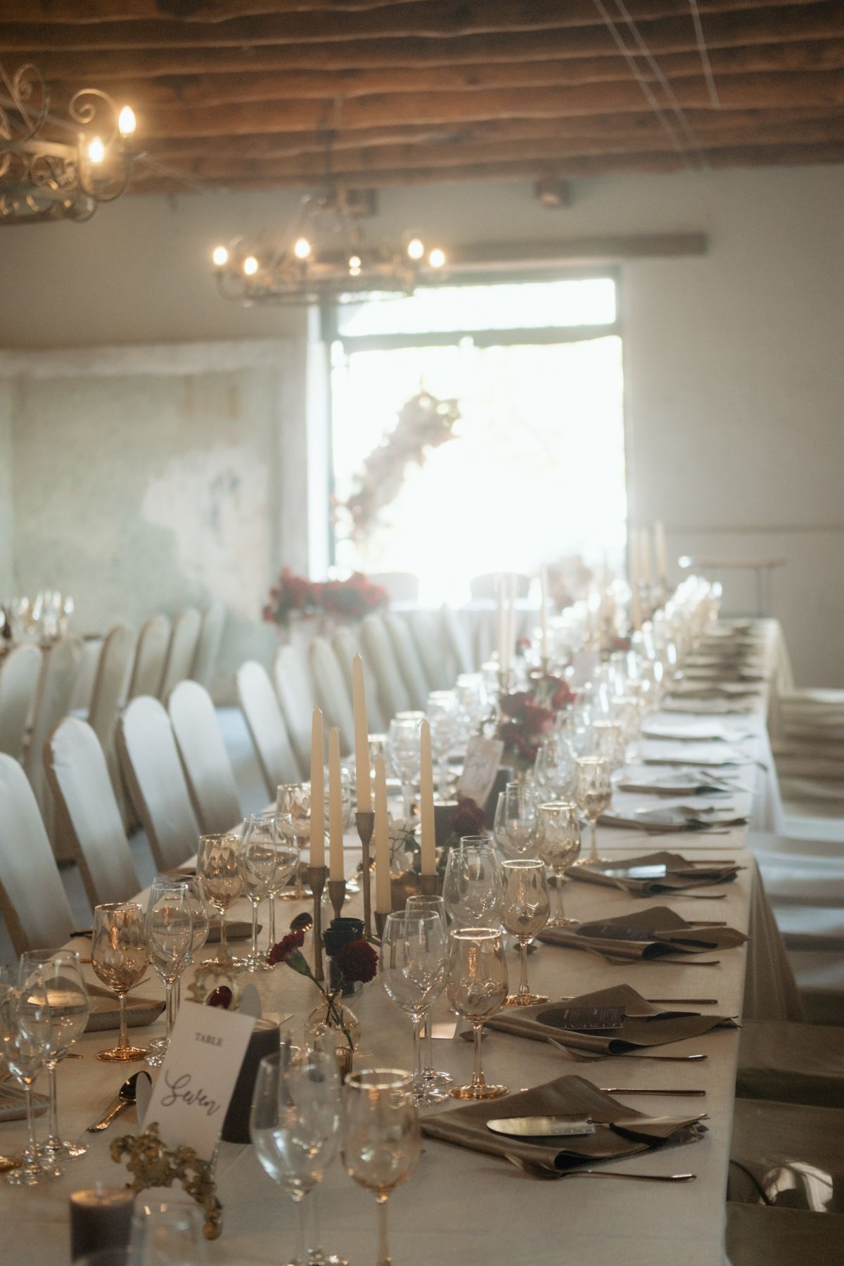 Long wedding banquet table with candles and floral centerpieces.