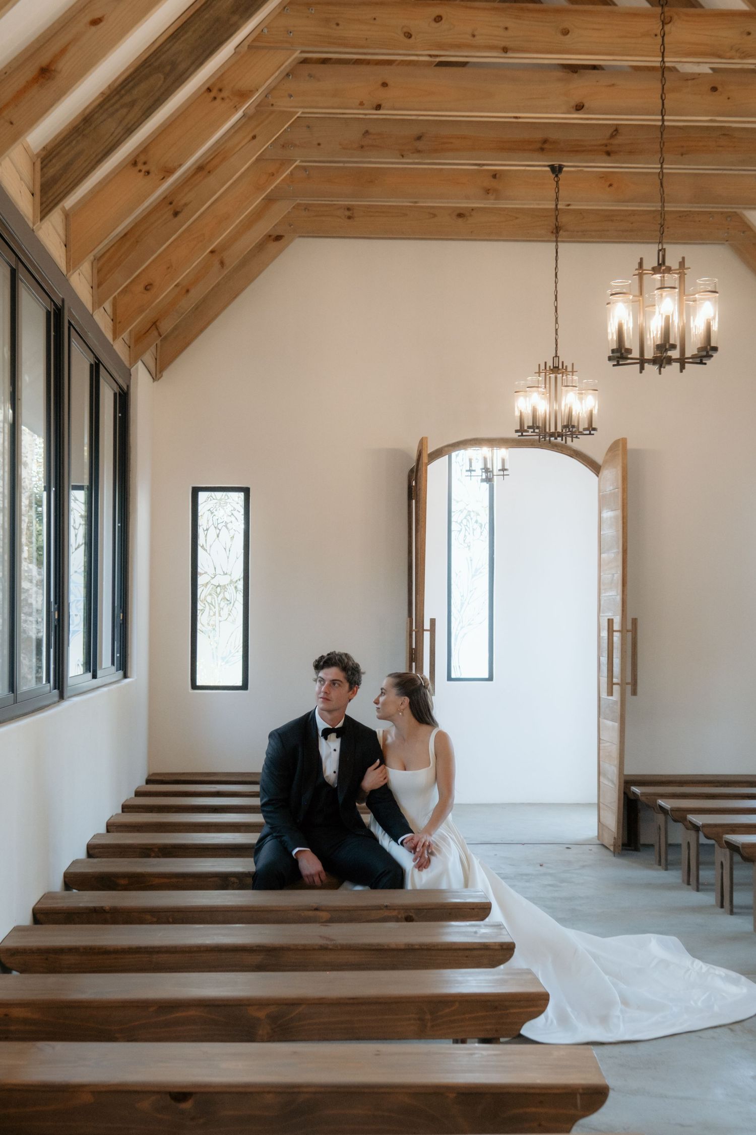 Rustic chapel interior with wooden pews and beamed ceiling capturing an intimate moment.