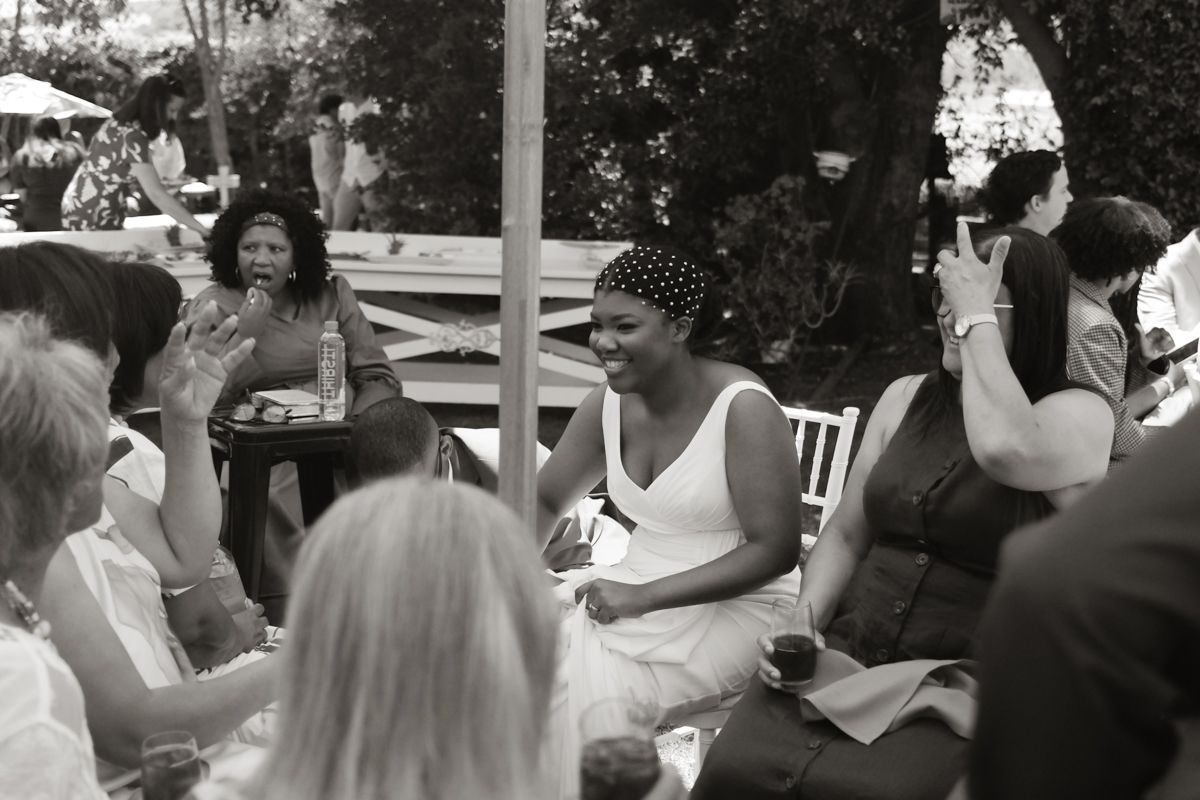 Black and white photo of women socializing at an outdoor garden party event.