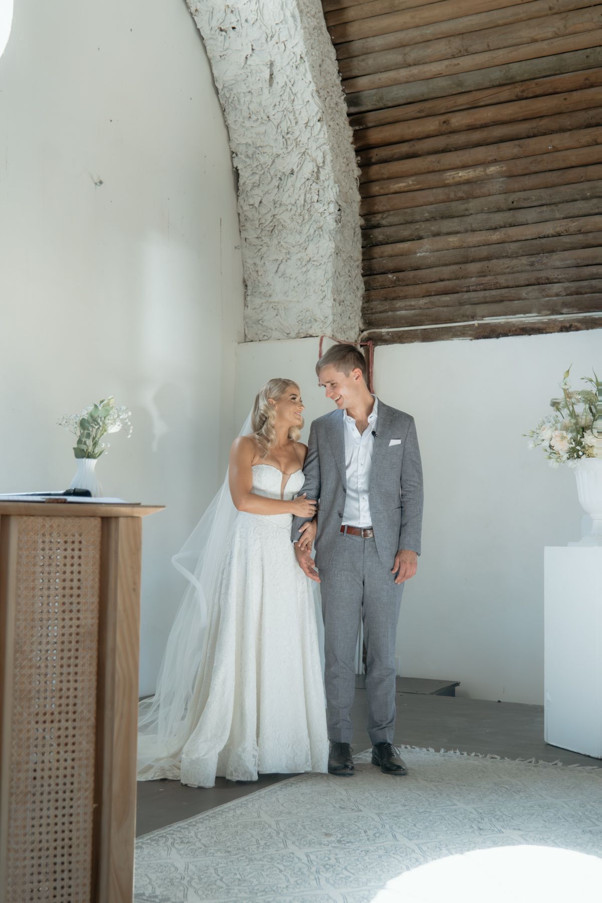 Bride and groom share an intimate moment at the altar inside a whitewashed arched chapel.