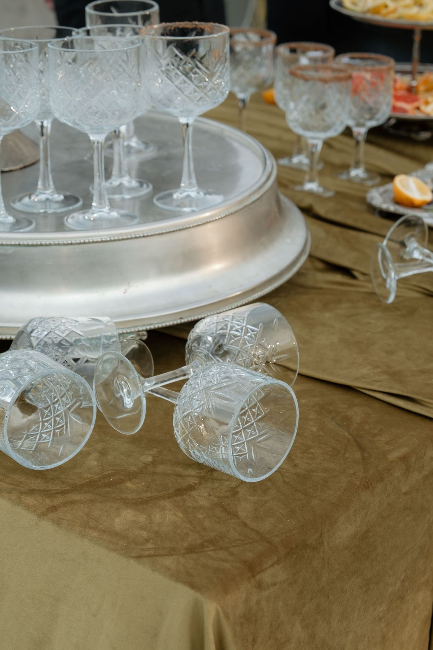 Crystal cut glass stemware arranged on silver tray at elegant wedding reception table.