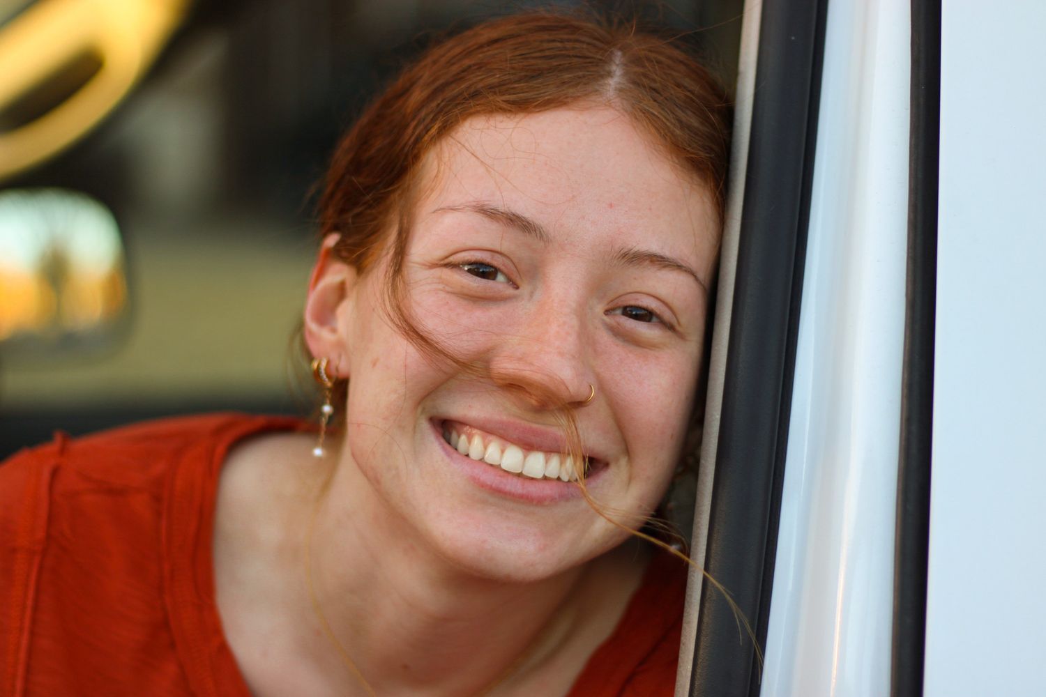 Girl leaning on inside of car door and smiling