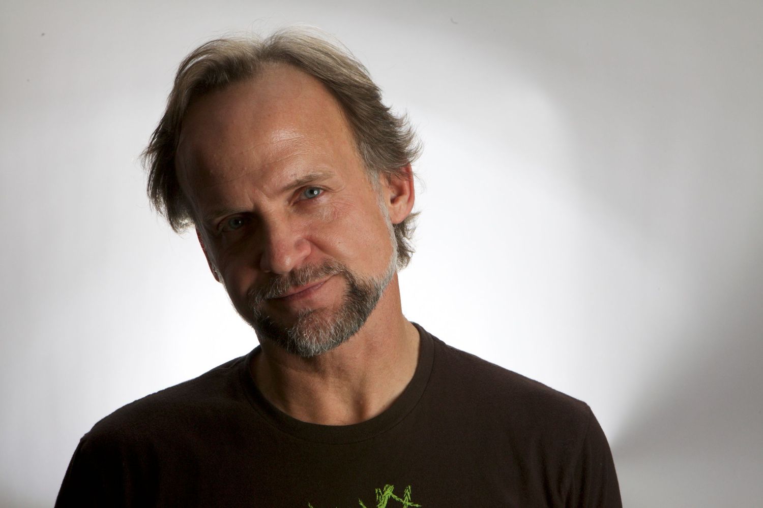 A series of headshots showing different expressions and angles of someone in dark clothing against a light background.