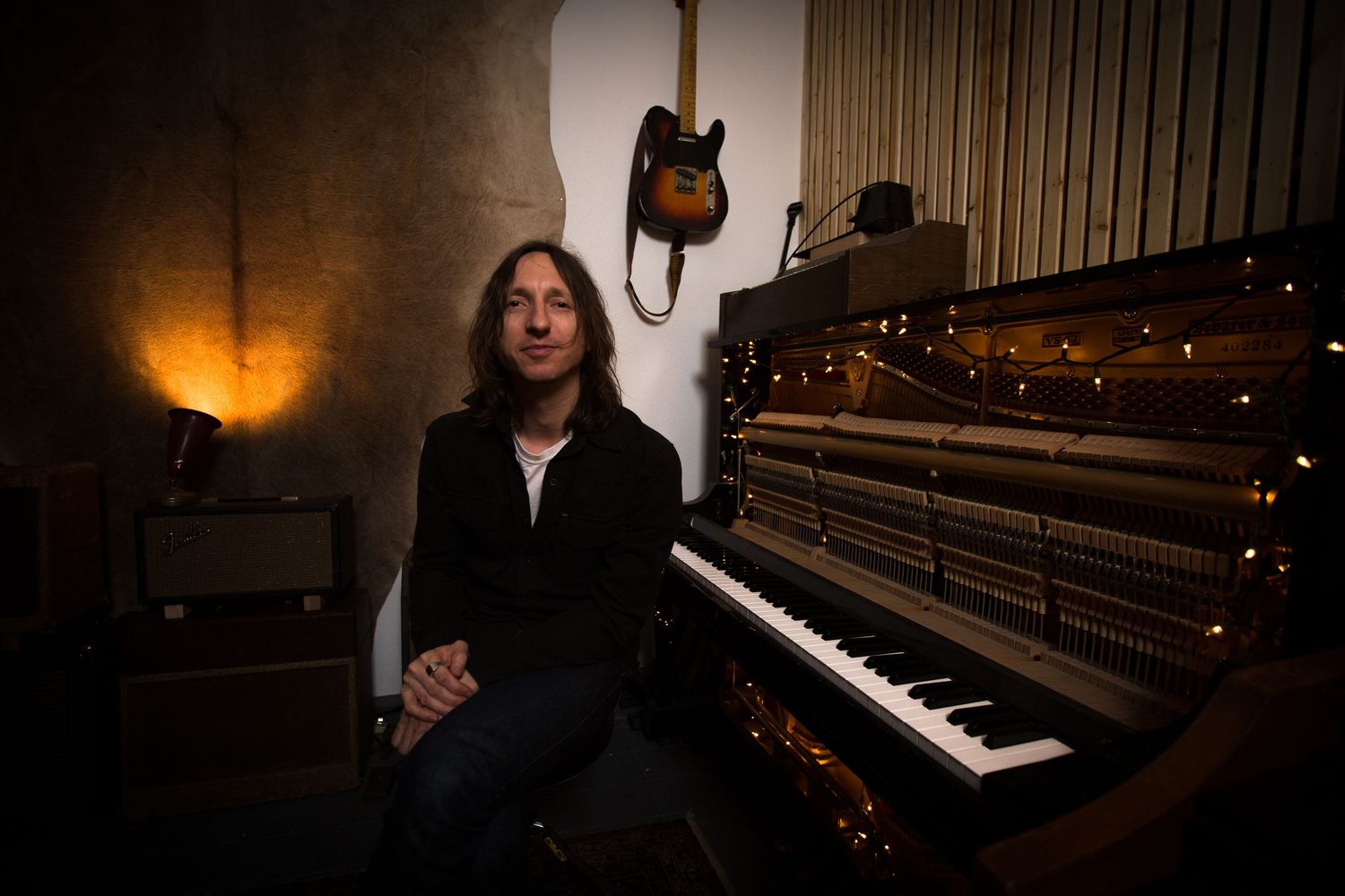 A moody collection of photos showing a piano in a dimly lit room with warm lighting and atmospheric shadows.