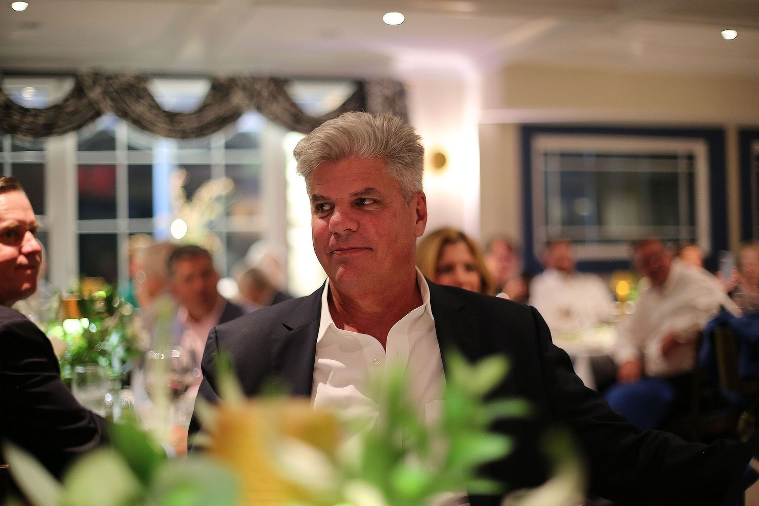 Guests enjoying conversation and laughter at an elegant indoor celebration event.
