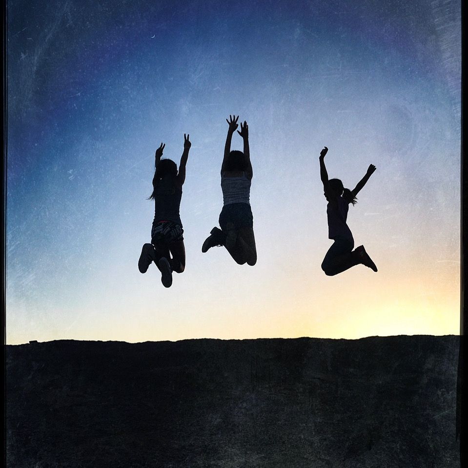 Silhouettes of people jumping against a sunset sky in sequence.