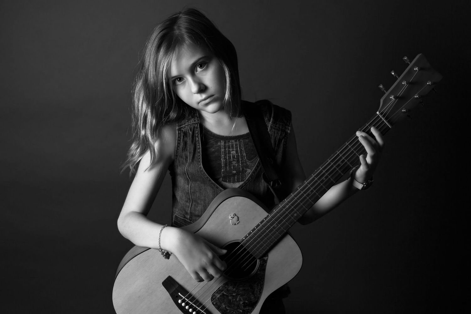 Artistic black and white portrait series showing someone holding and playing an acoustic guitar.