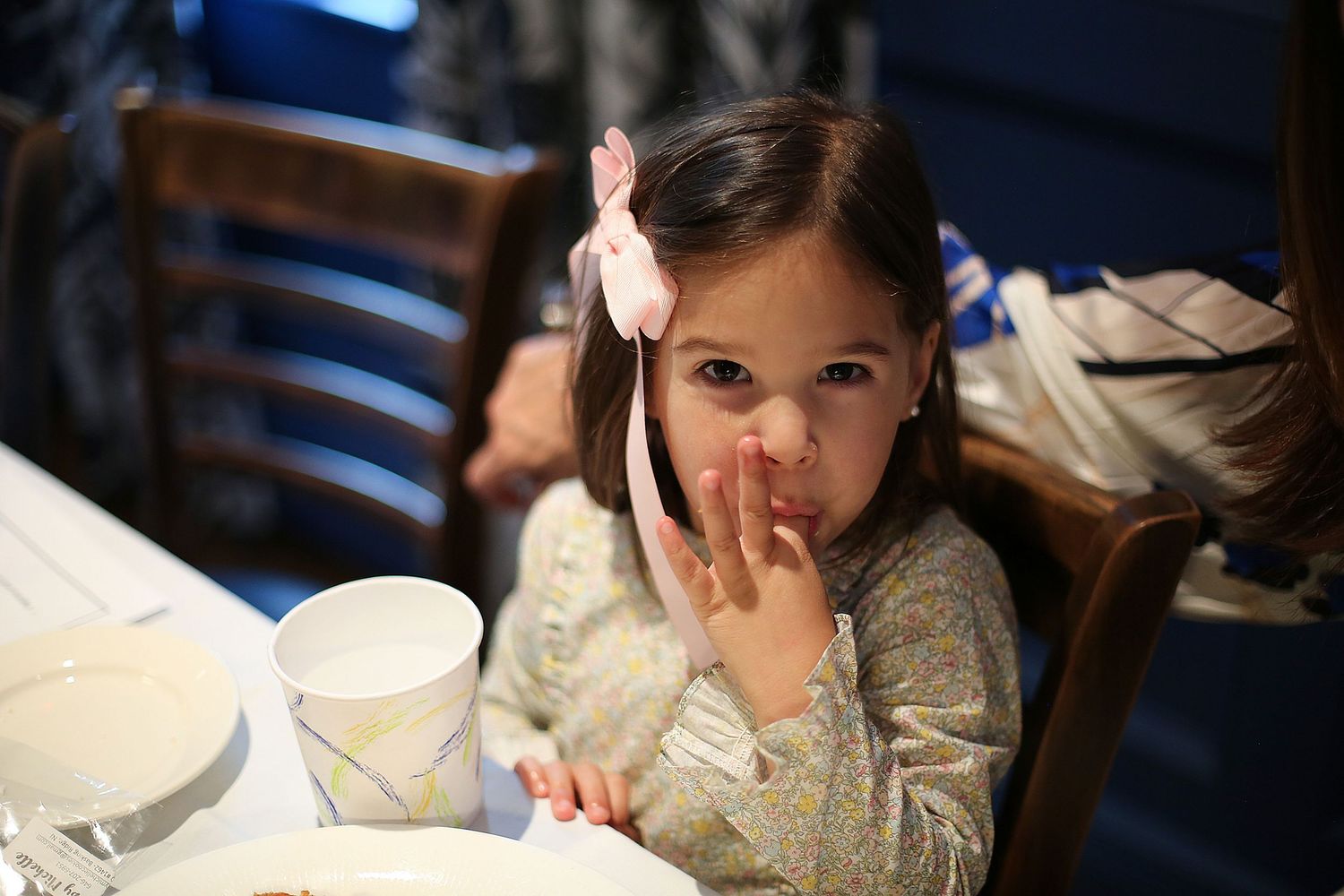 Person sitting at a dimly lit table during an evening event.