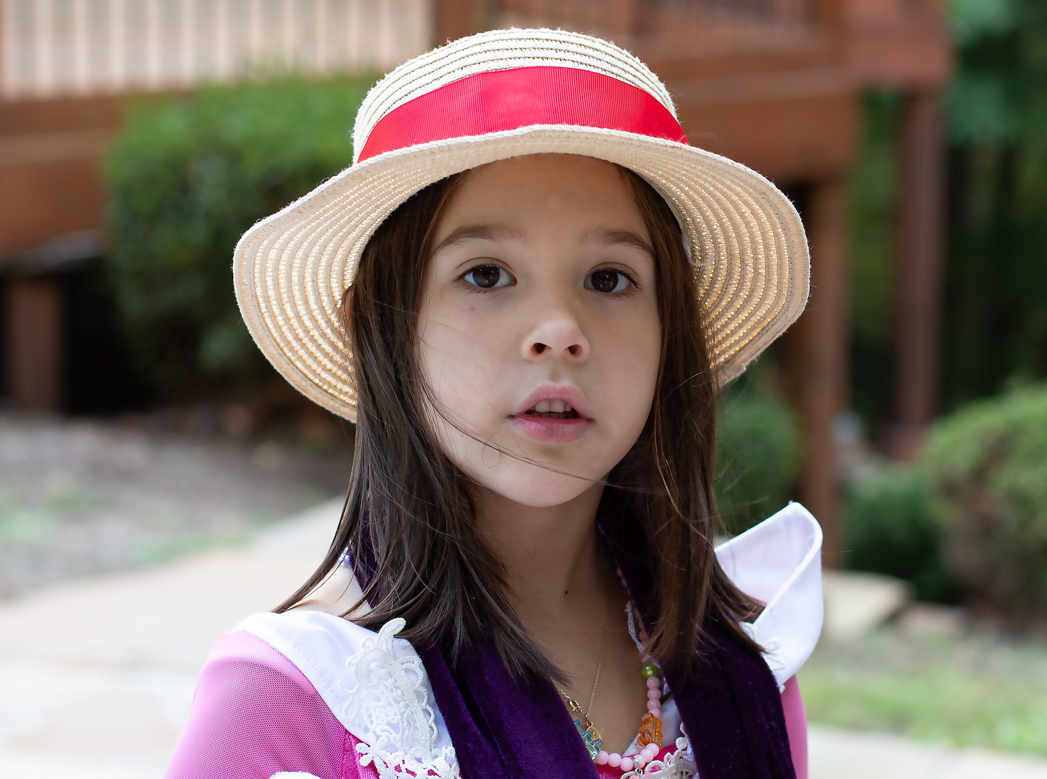 A sequence of outdoor portraits showing a child wearing a sun hat and colorful clothing.
