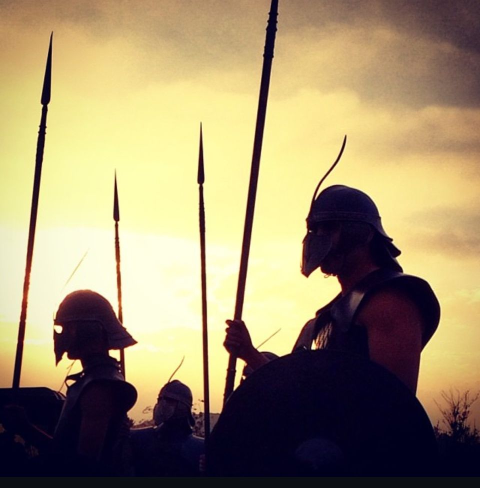 Silhouettes of people holding instruments against a dramatic sunset sky.