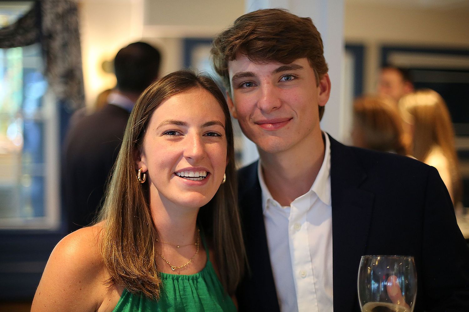 Celebratory dinner gathering at a restaurant with formal dress and warm lighting.